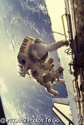 astronaut floating next to craft